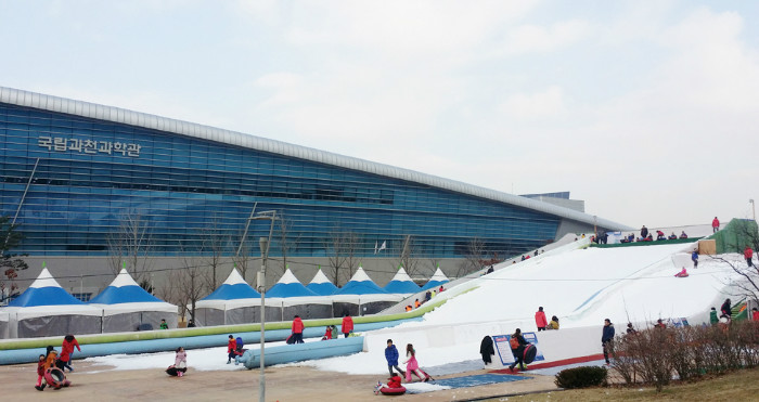 Visitors sledding down a slope outside the GNSM.